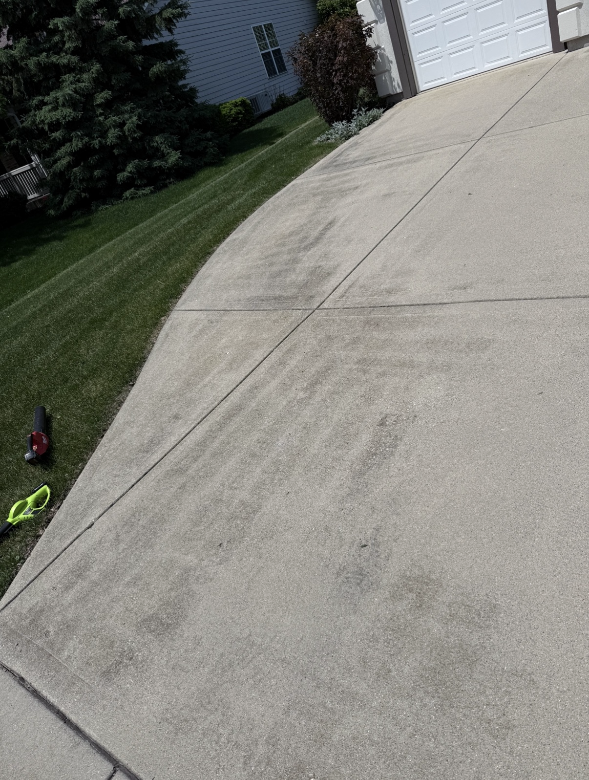 Stained driveway with pressure washer before cleaning