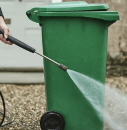 Pressure washing a garbage bin
